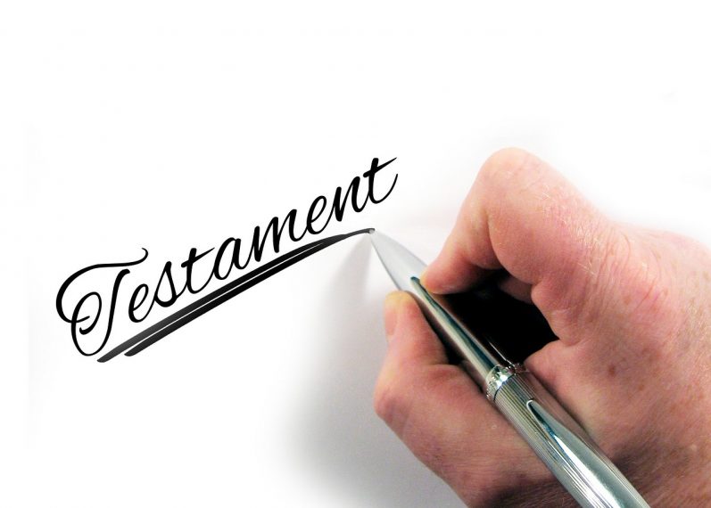 Hand mit Stift schreibt Testament